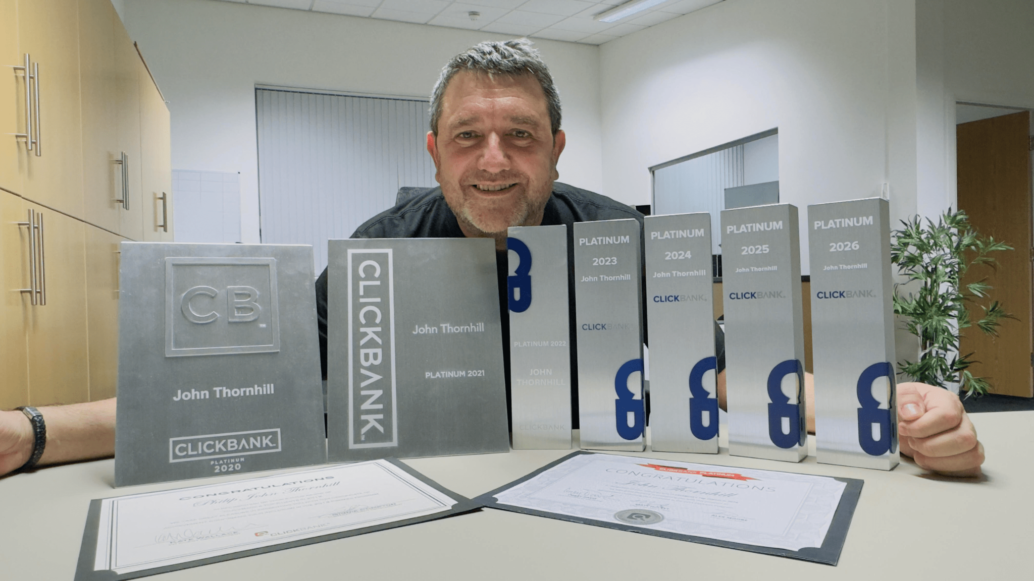 John Thornhill pictured with ClickBank Platinum awards